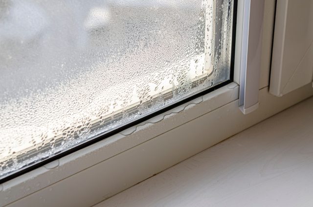 Drops of condensate and black mold on a substandard metal-plastic window, window replacement signs, energy-efficient windows, drafty windows, condensation between glass, increased energy bills, window damage, home improvement, window upgrade, Seaberg Construction, window replacement Rhode Island